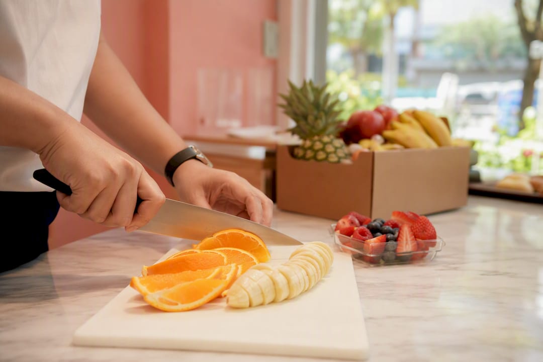 Hands preparing fresh fruit snack on cutting board