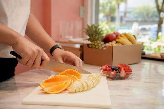 Hands preparing fresh fruit snack on cutting board